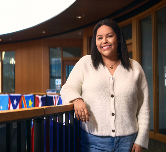 Senior Sydney Baltuck sitting cross legged outside the Myrtle Woldson Performing Arts Center.